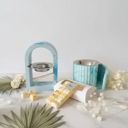 Brûle-parfum artisanal en jesmonite bleu marbré - modèles arche et escalier avec fondants parfumés Monoï, feuilles tropicales et fleurs séchées sur marbre blanc - Les Créations des A