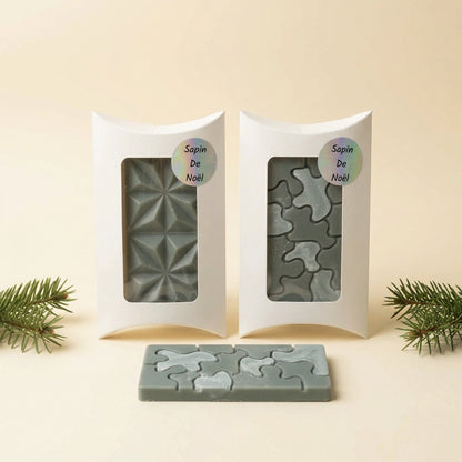 Fondants parfumés Sapin de Noël en cire vert sauge présentés dans deux boîtes blanches avec fenêtre et un fondant puzzle posé devant - Les Créations des A