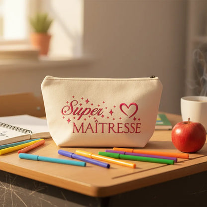 Pochette beige "Super Maîtresse" posée sur un bureau avec crayons de couleur et pomme – Idée cadeau fin d'année enseignante – Les Créations des A