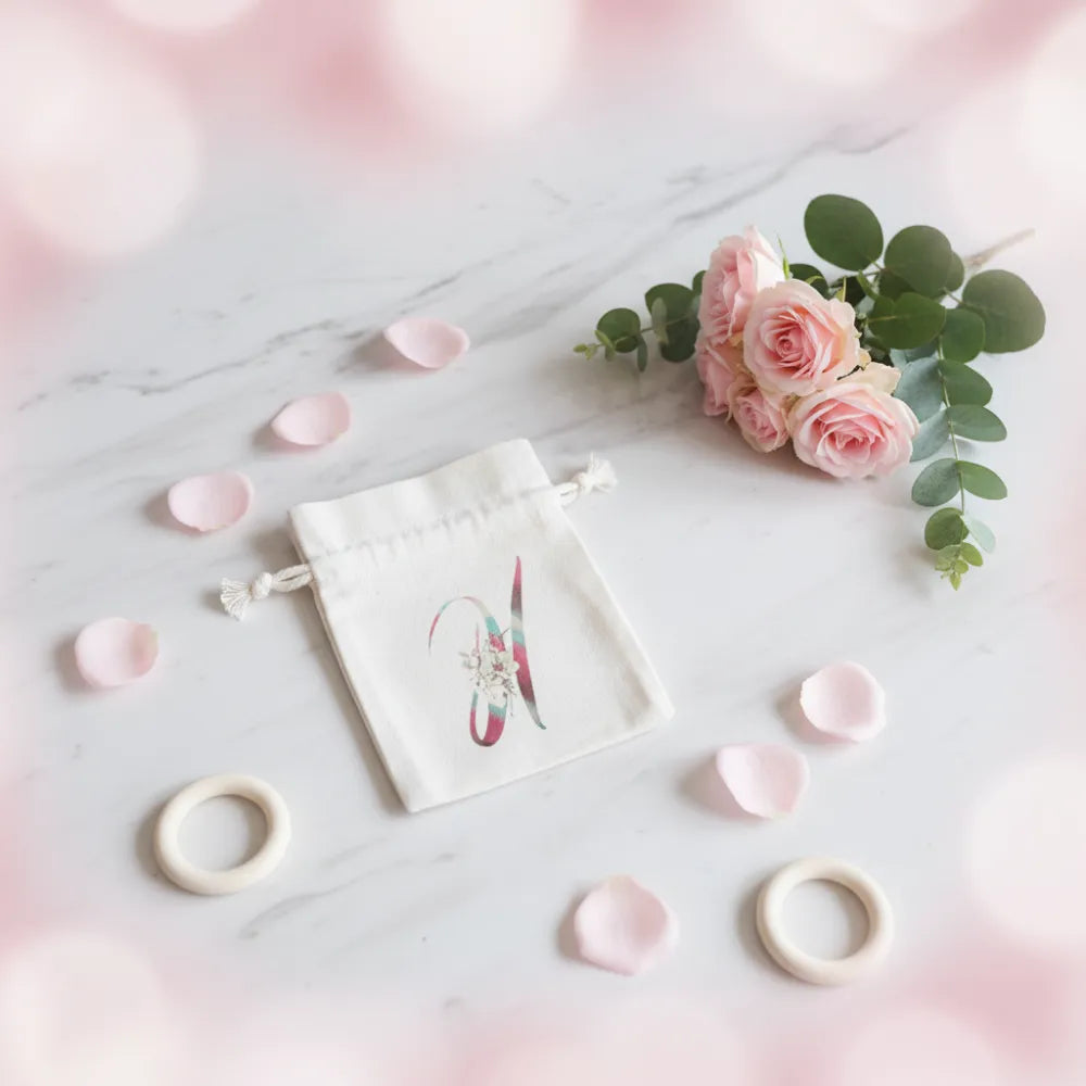 Pochon en coton blanc avec initiale lettre personnalisée sur fond blanc et pétales de roses – cadeau original -Les Créations des A