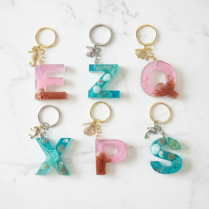Porte-clés personnalisés en résine avec initiales, disponibles en collection Lagon bleu turquoise et Corail rose, réalisés à la main avec breloques marines - Les Créations des 
