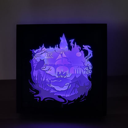 Shadow box lumineuse artisanale inspirée d'un univers de sorciers. Décor multicouche représentant un château magique, un train légendaire et plusieurs éléments fantastiques avec éclairage LED multicolore - Les Créations des A
