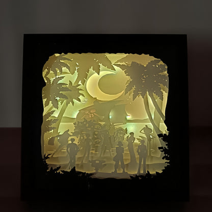 Shadow box lumineuse artisanale inspirée d'un univers de pirates. Décor multicouche représentant un équipage d'aventuriers, un grand navire et un paysage tropical avec éclairage LED - Les Créations des A