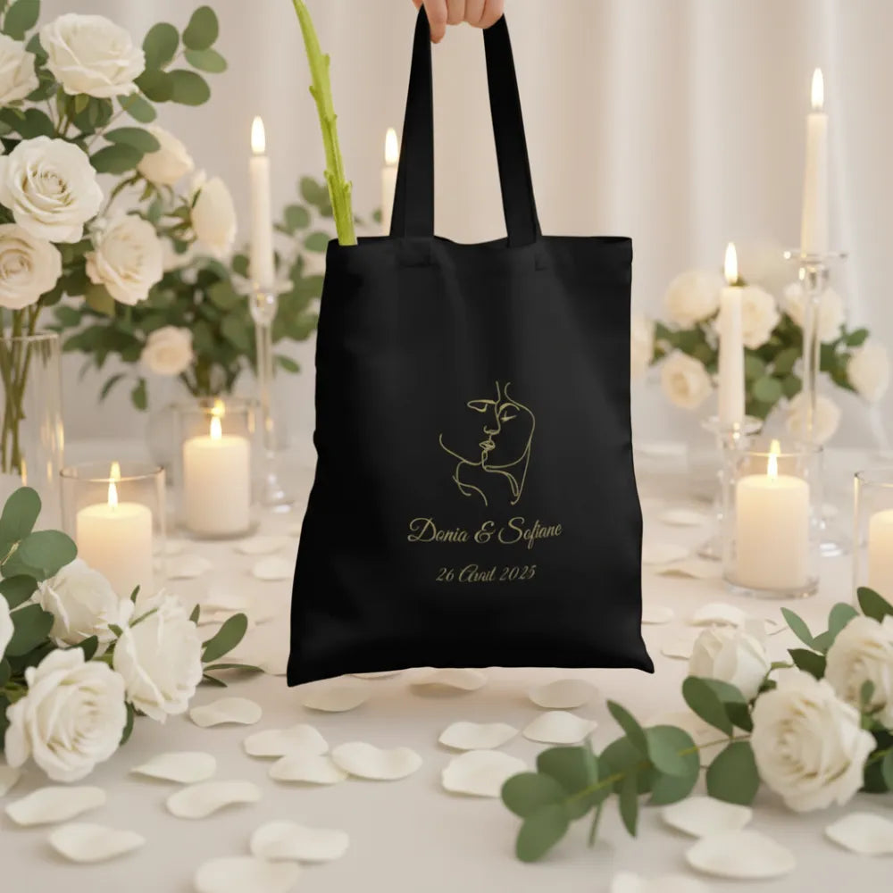 Mariée portant un tote bag noir doré personnalisé dans un château – souvenir mariage EVJF - Les Créations des A