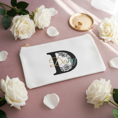 Trousse toile blanche personnalisée avec lettre florale D arc-en-ciel, posée sur velours rose poudré avec roses blanches - Les Créations des A